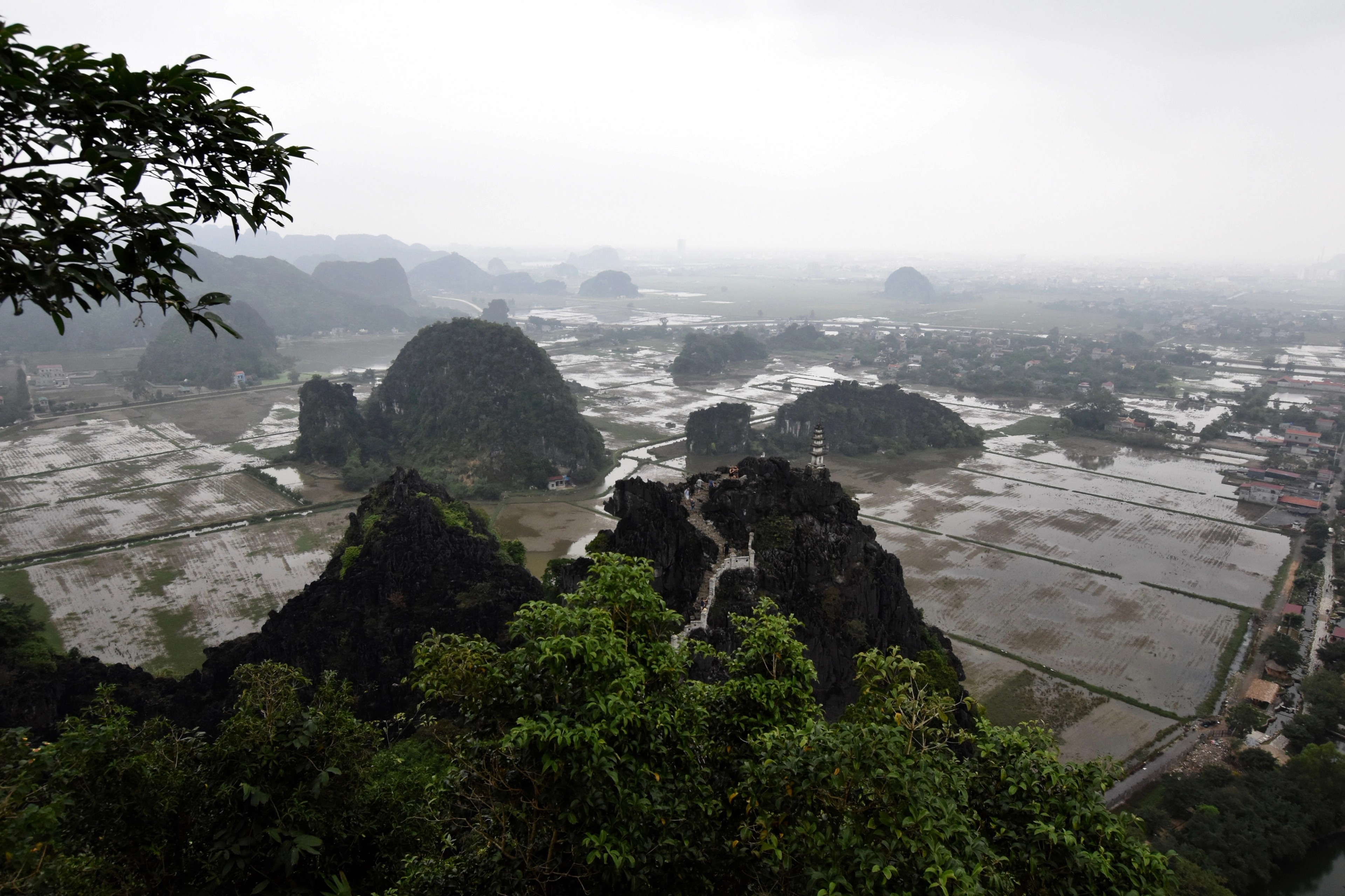 A broad river valley and limestone hills are seen from a rocky overlook.