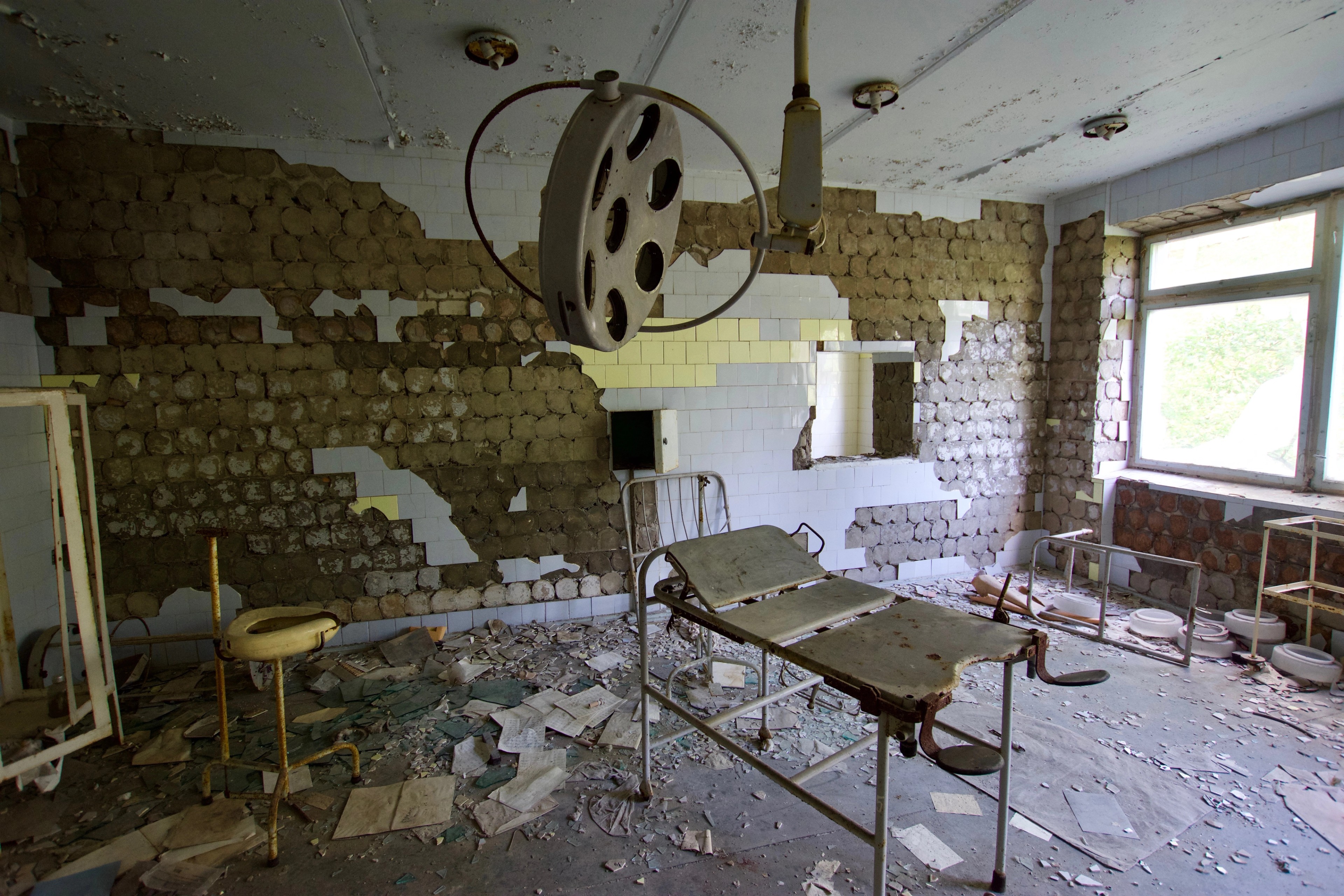 An old medical examination chair stands in a tiled room.