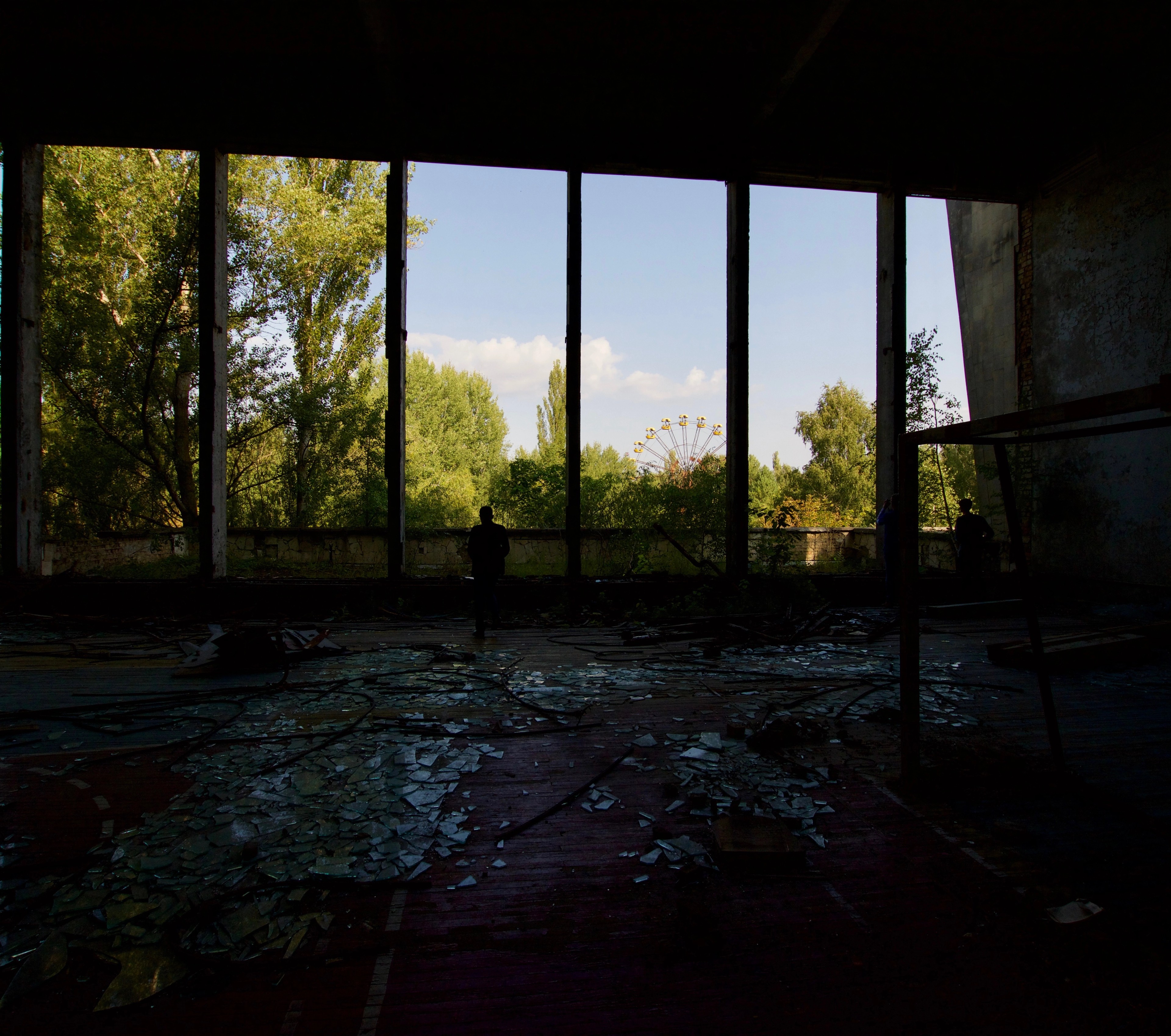 A dark abandoned room with exposed beams and a window.