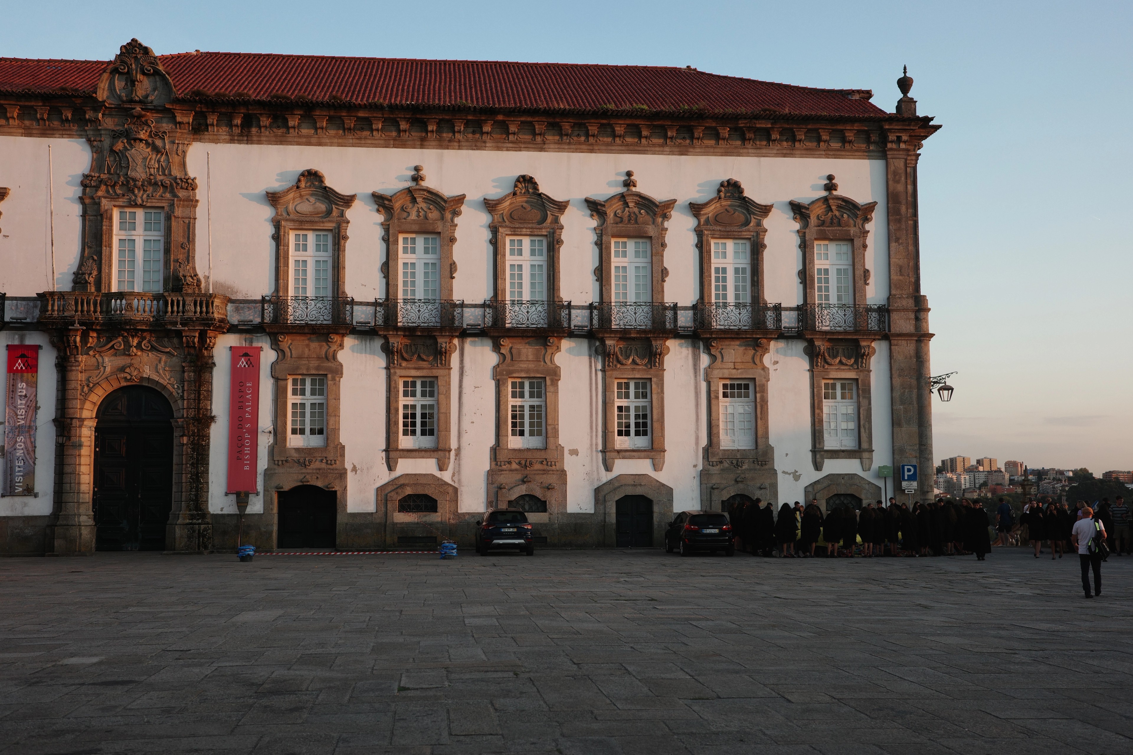 A grand ornate building stands across a broad square at dusk.