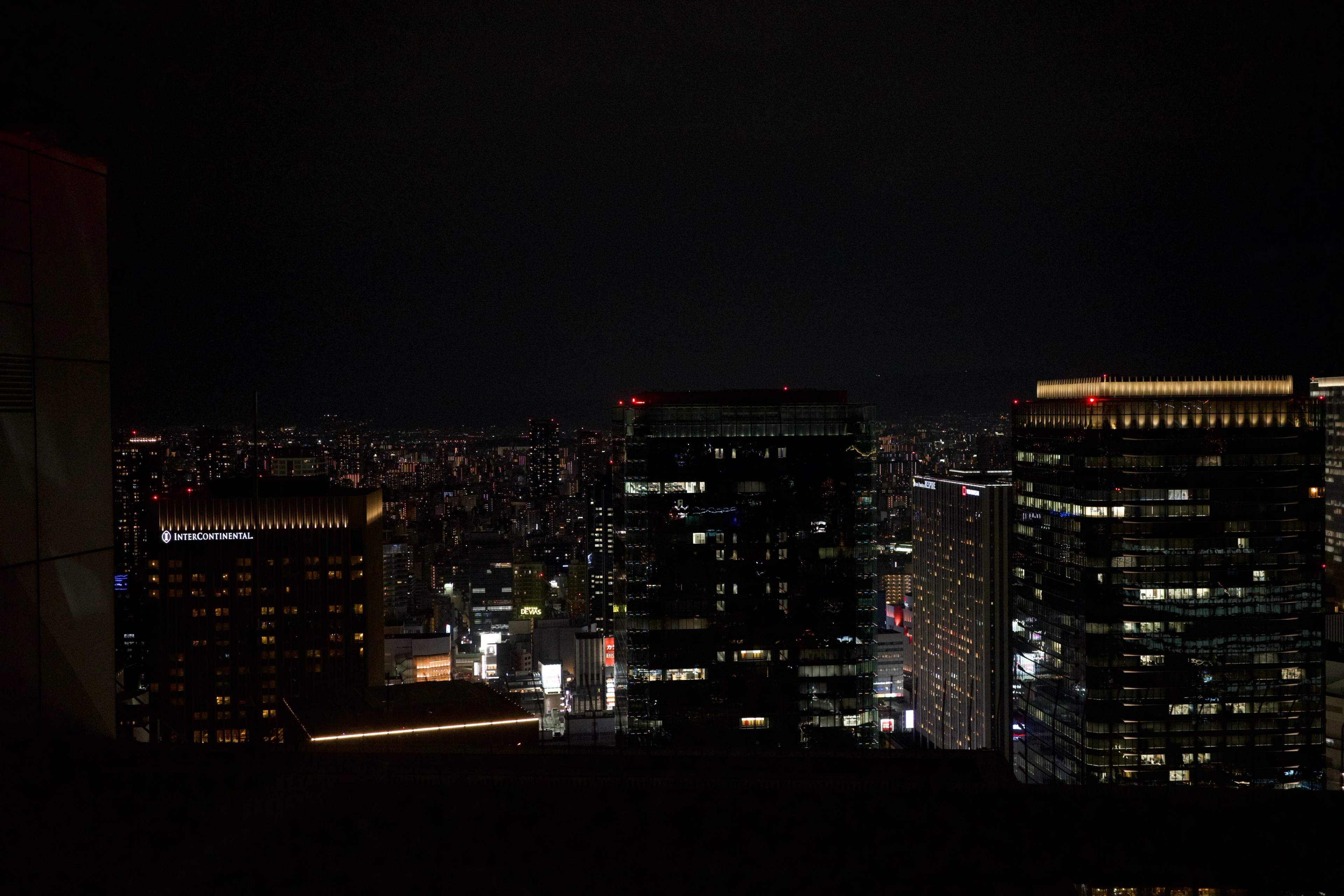 High-rise offices glow above the city at night.
