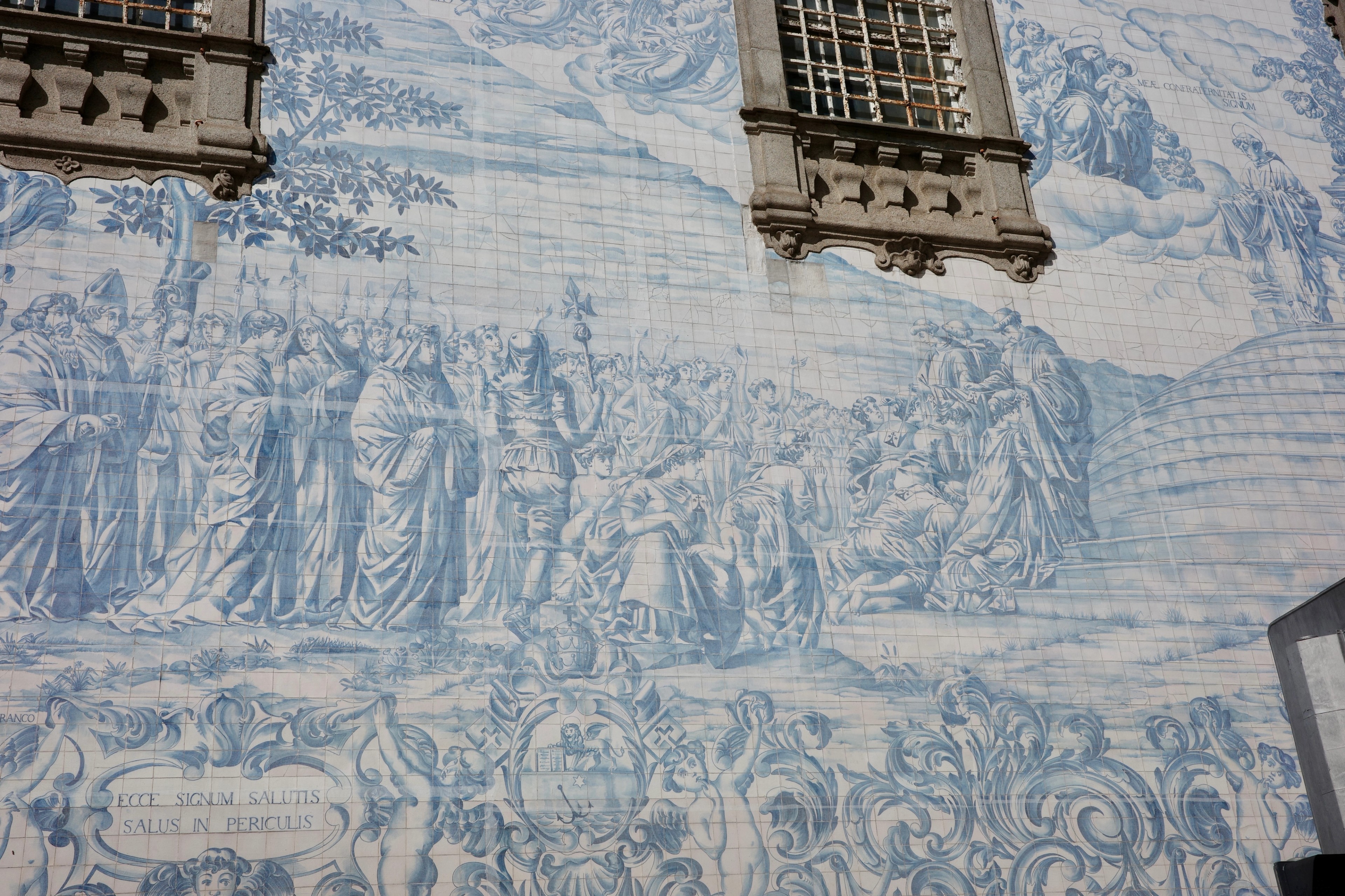A blue-and-white tiled mural stretches across the wall between two windows.