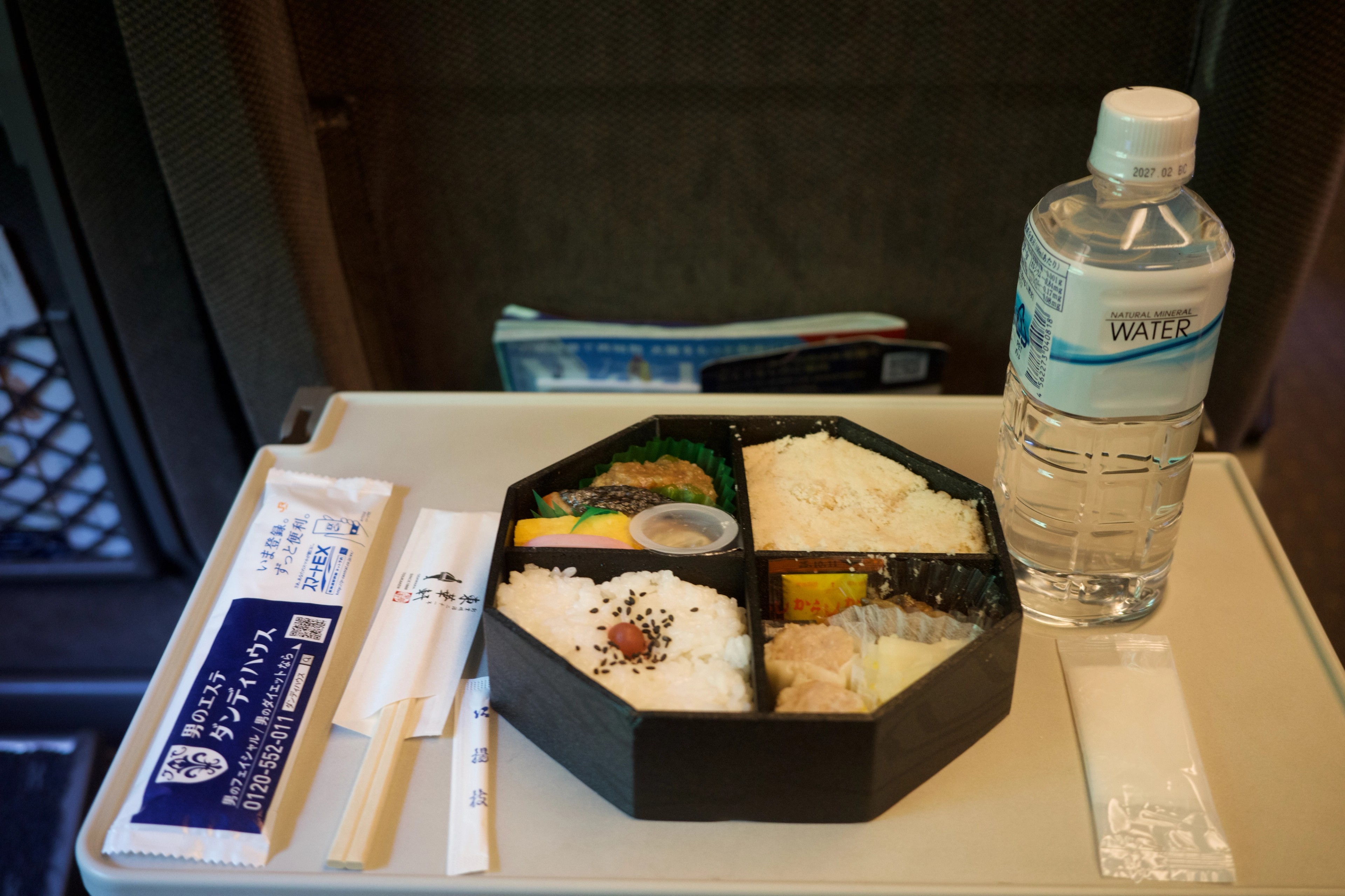A boxed meal and bottled drink sit on a table.