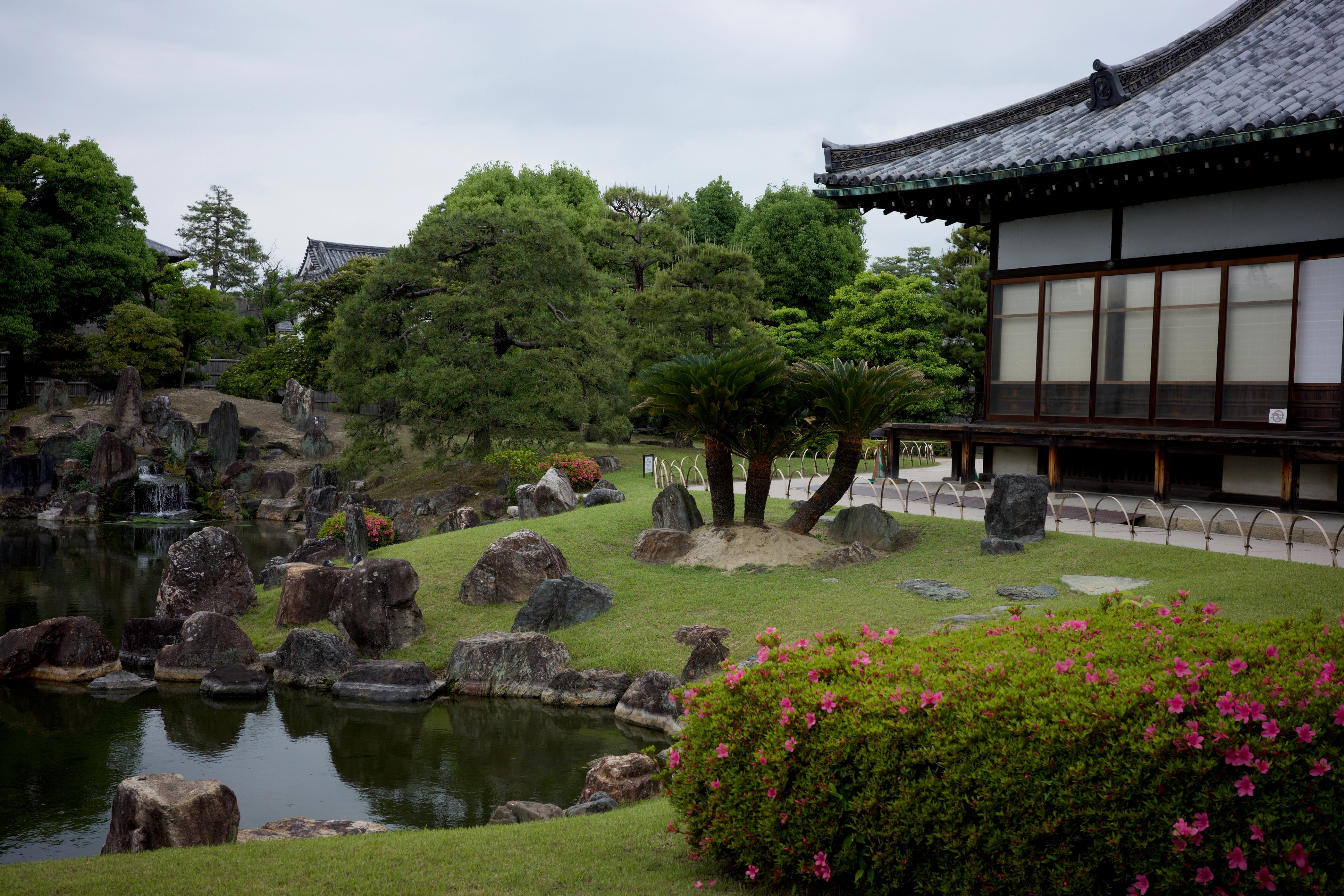 A traditional building overlooks a garden pond.