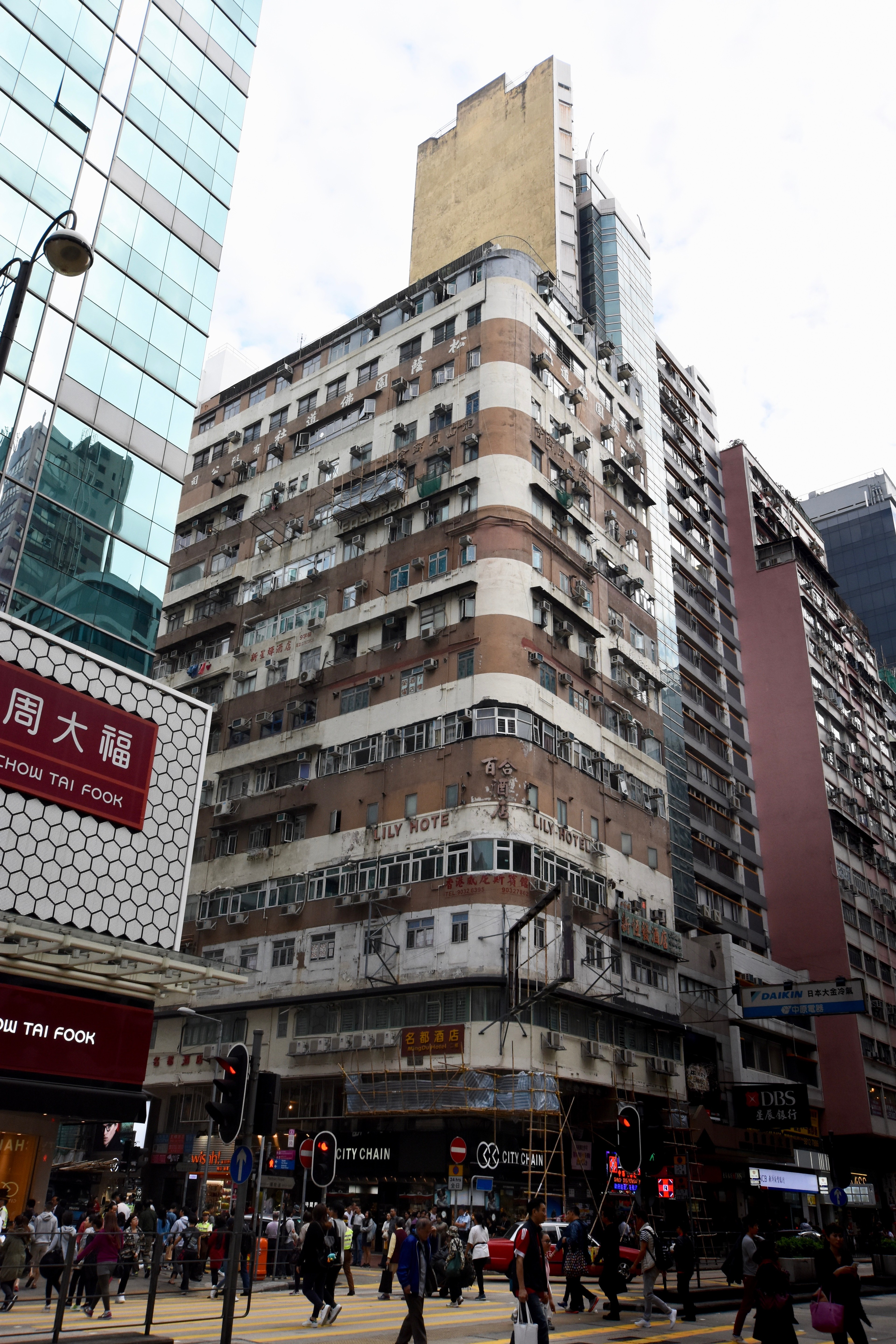 A crowded apartment building stands above a busy city intersection.