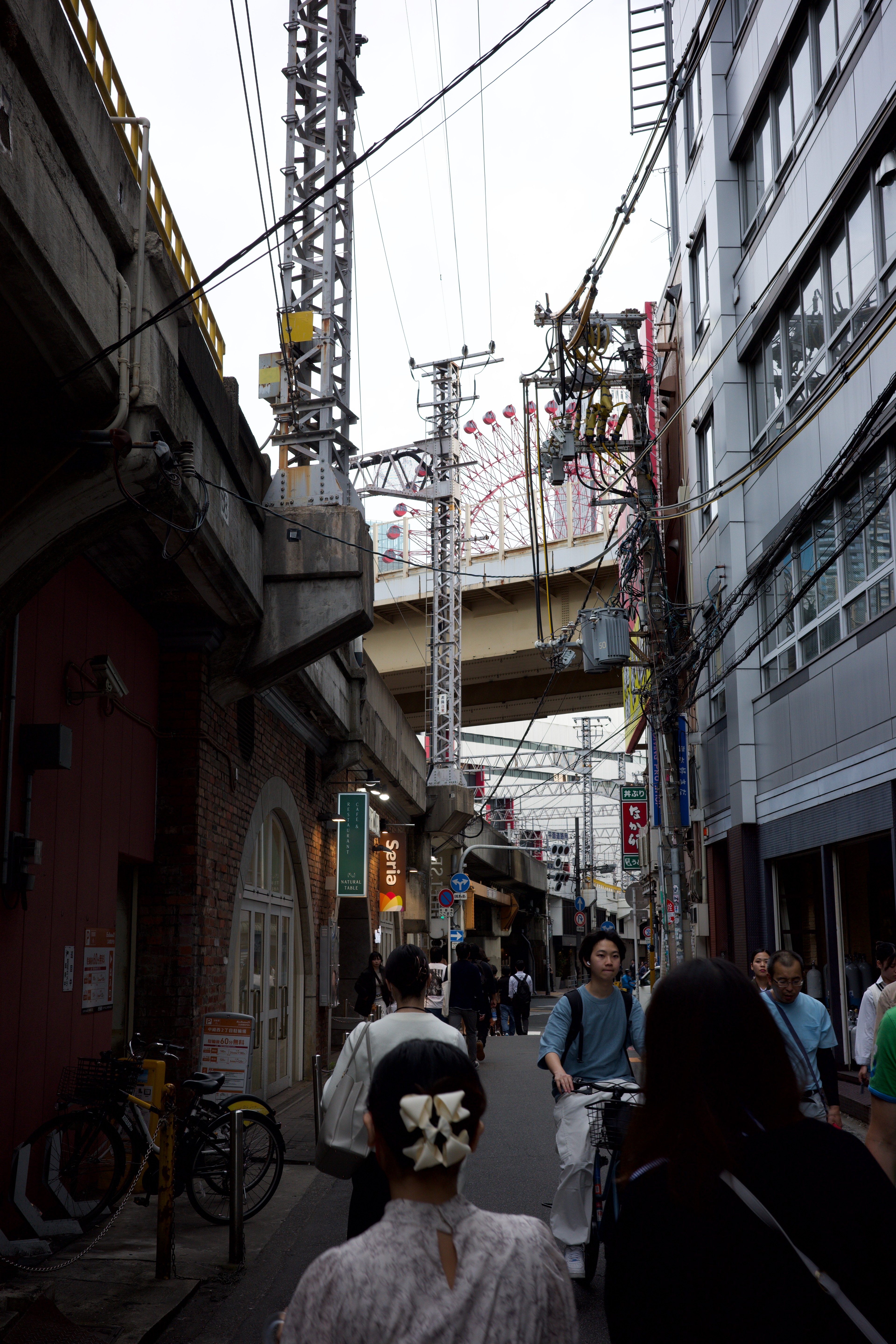 People move through a narrow alley between tall buildings.
