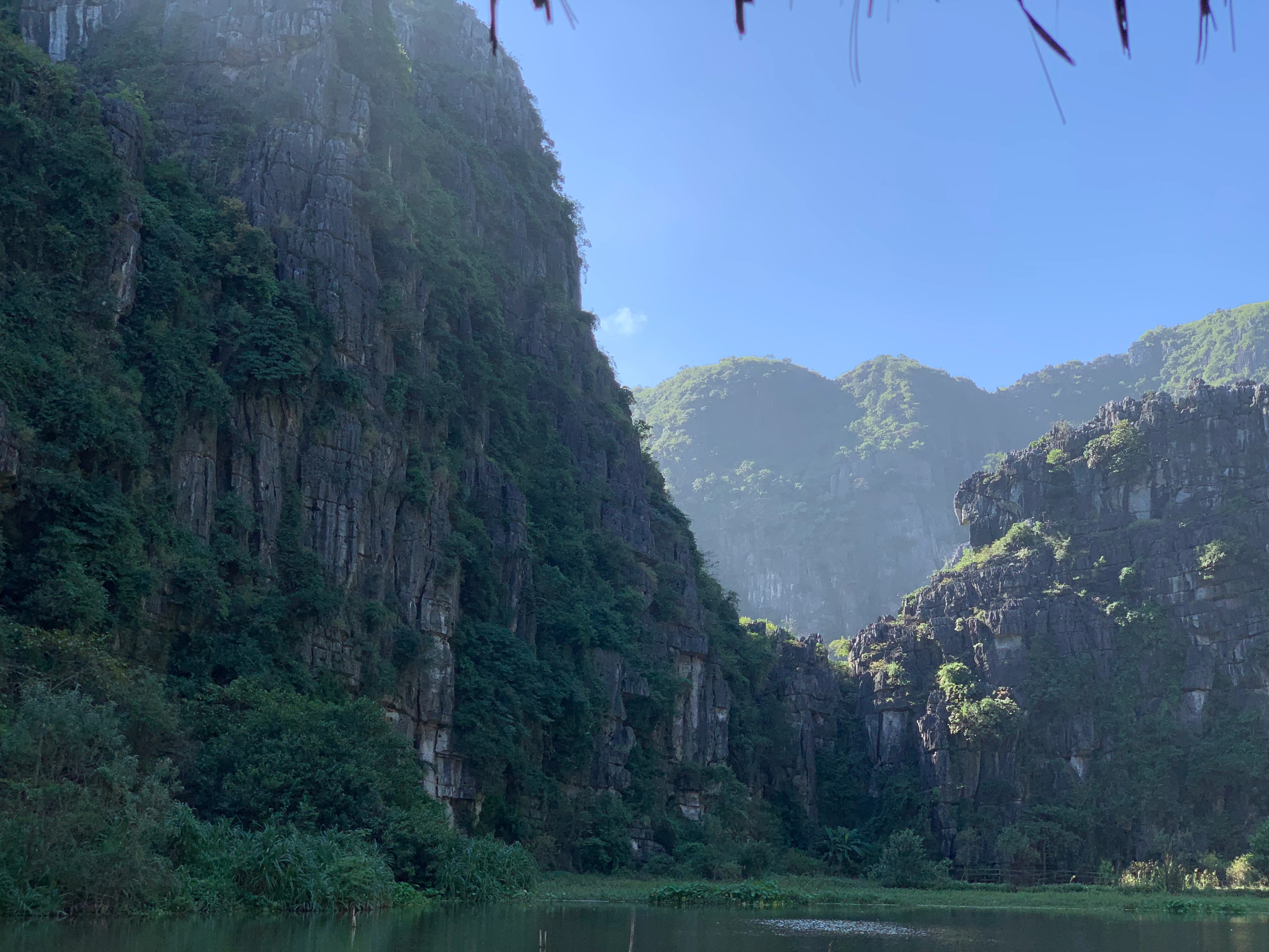 A green river valley winds between steep limestone hills.