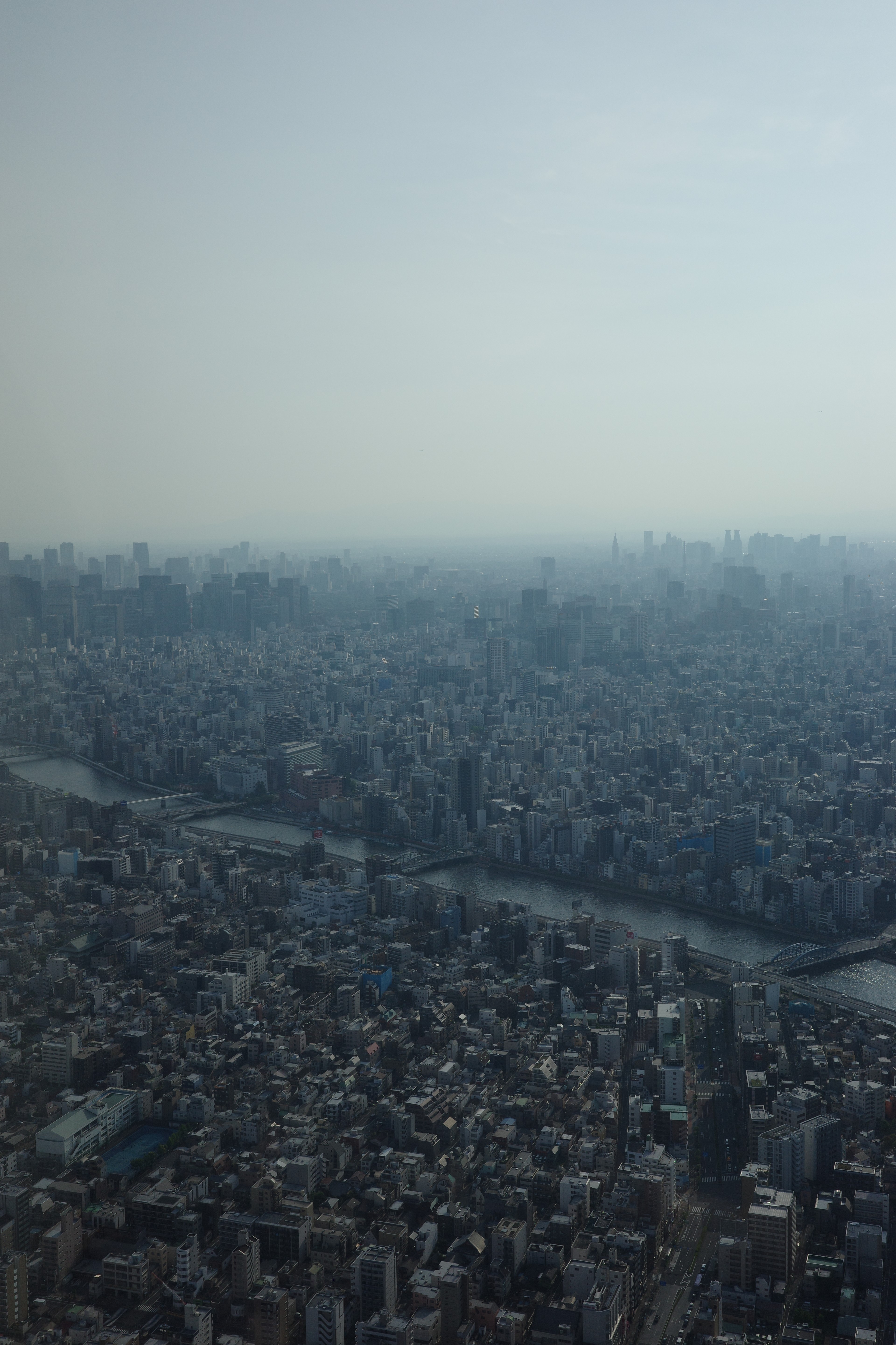 A hazy city skyline seen from a high-rise.