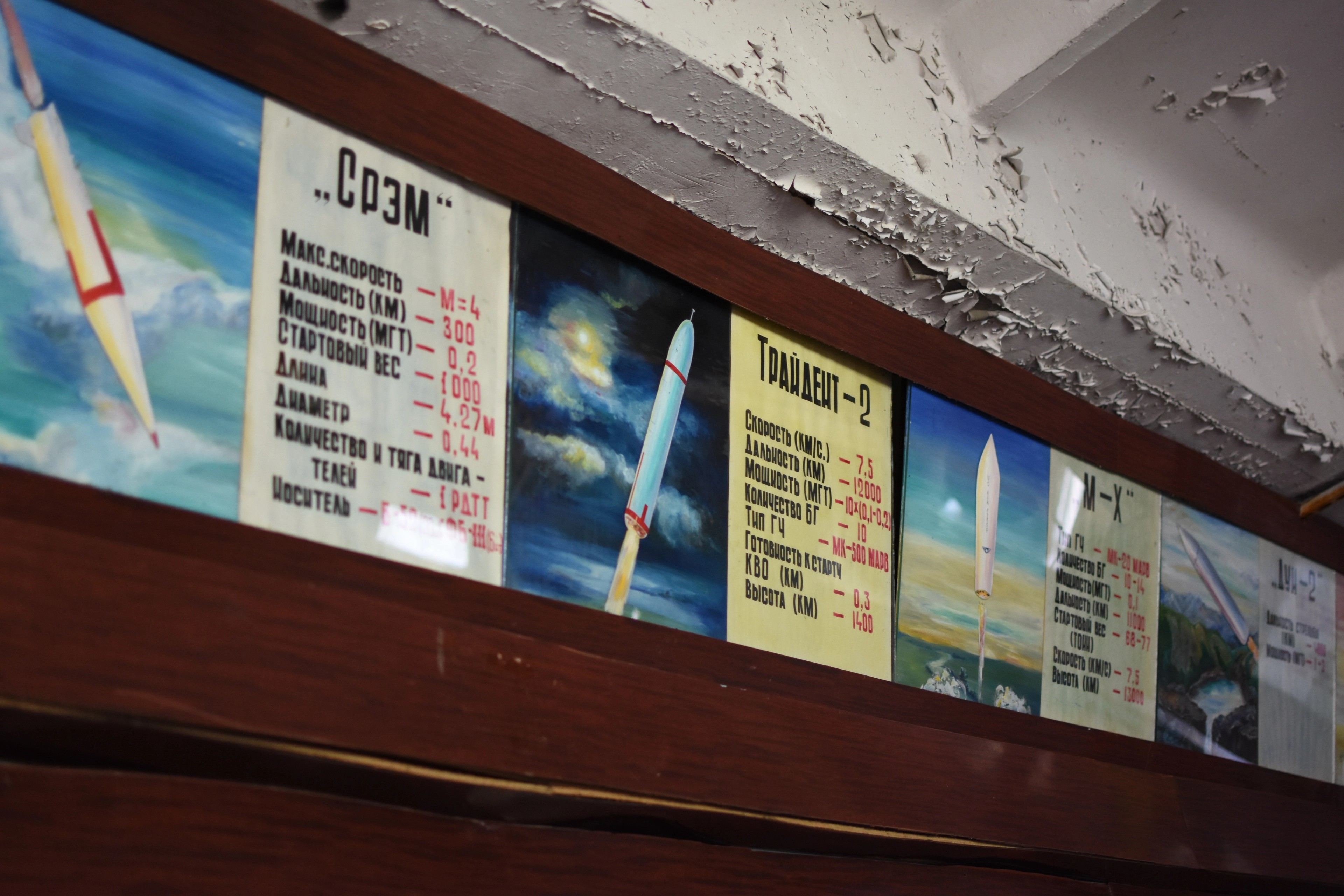 A wall display shows a timeline and science posters.