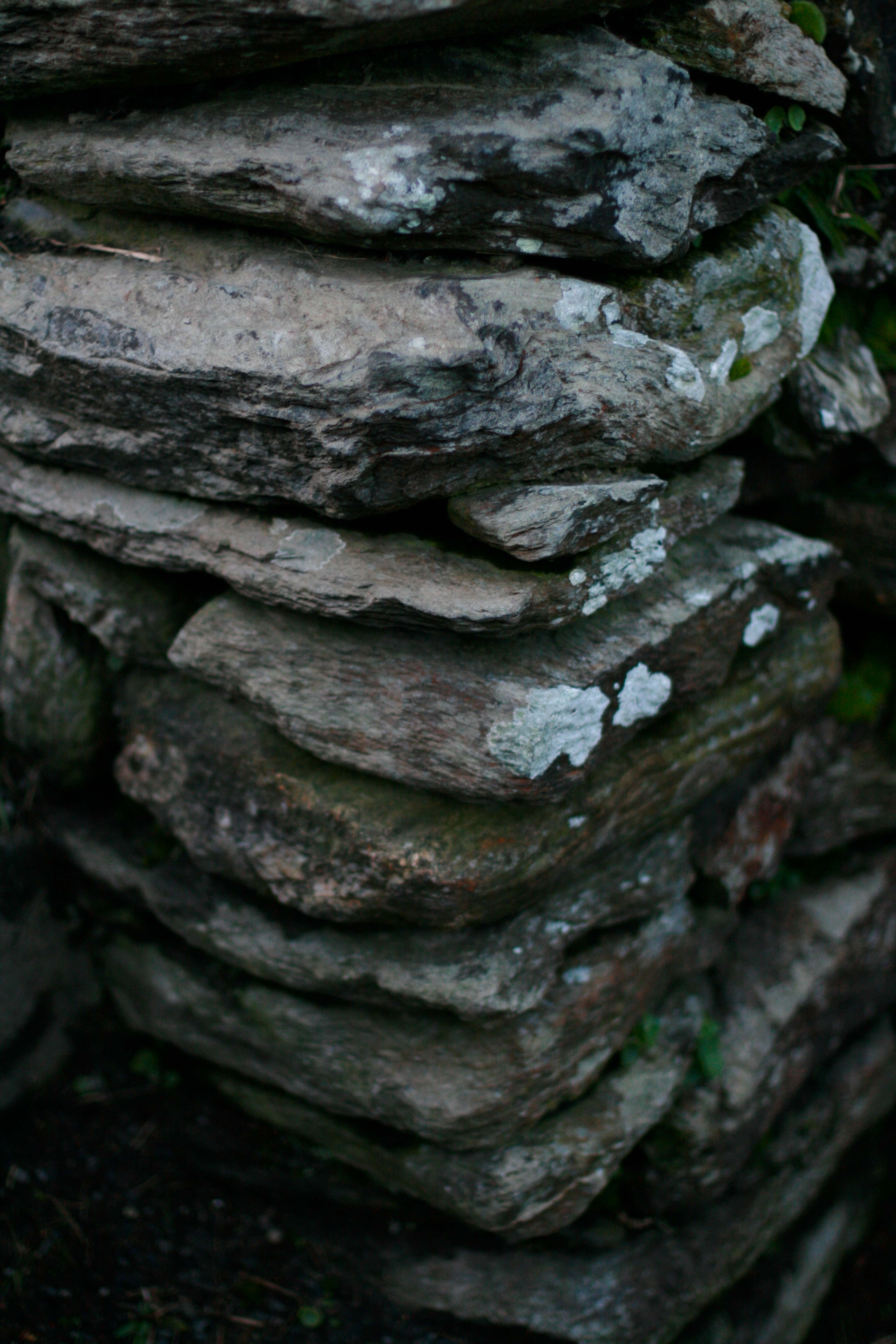 A close view of stacked flat stones forming a low wall.