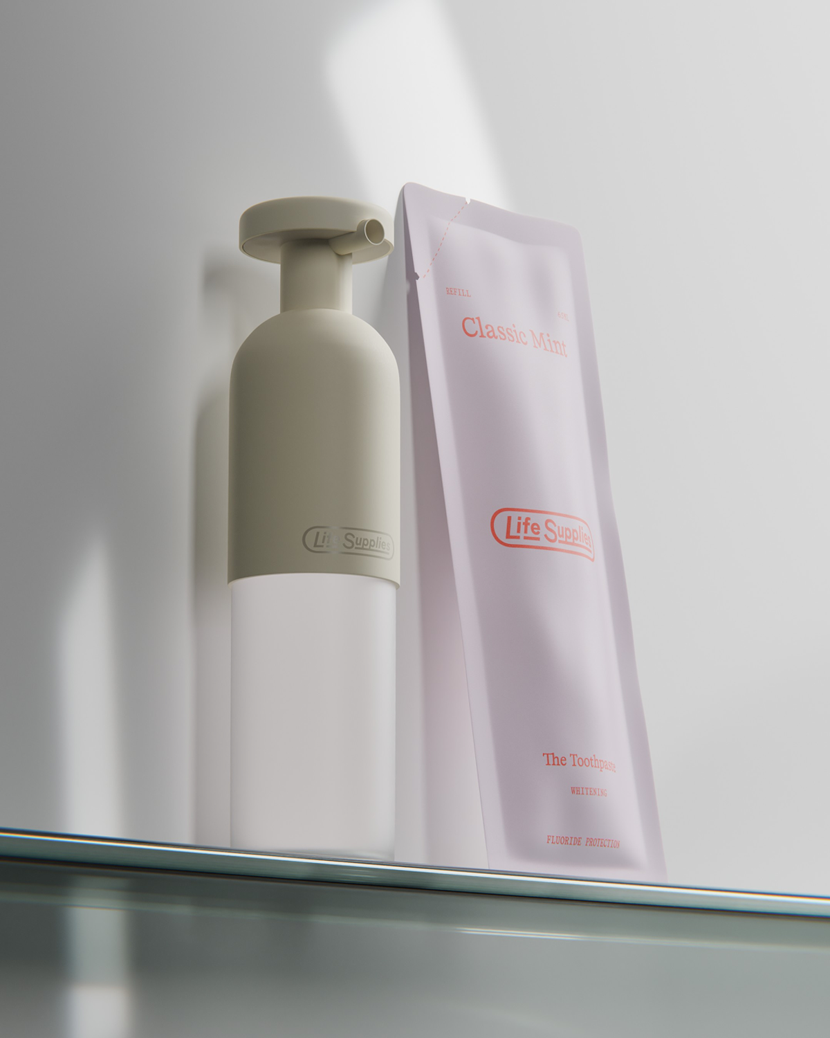 A beige pump dispenser and a light purple packet of Life Supplies Classic Mint toothpaste are displayed on a shelf. The toothpaste packet indicates "Whitening" and "Fluoride Protection."