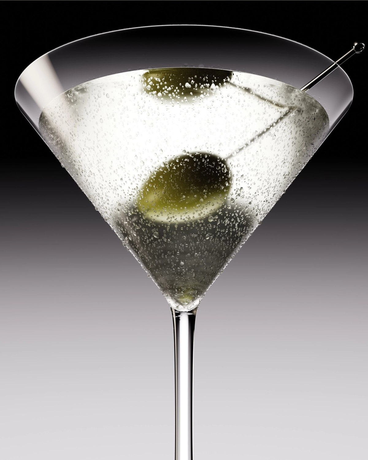 A martini glass containing a clear liquid, ice, and two olives. A cocktail pick rests in the glass.
