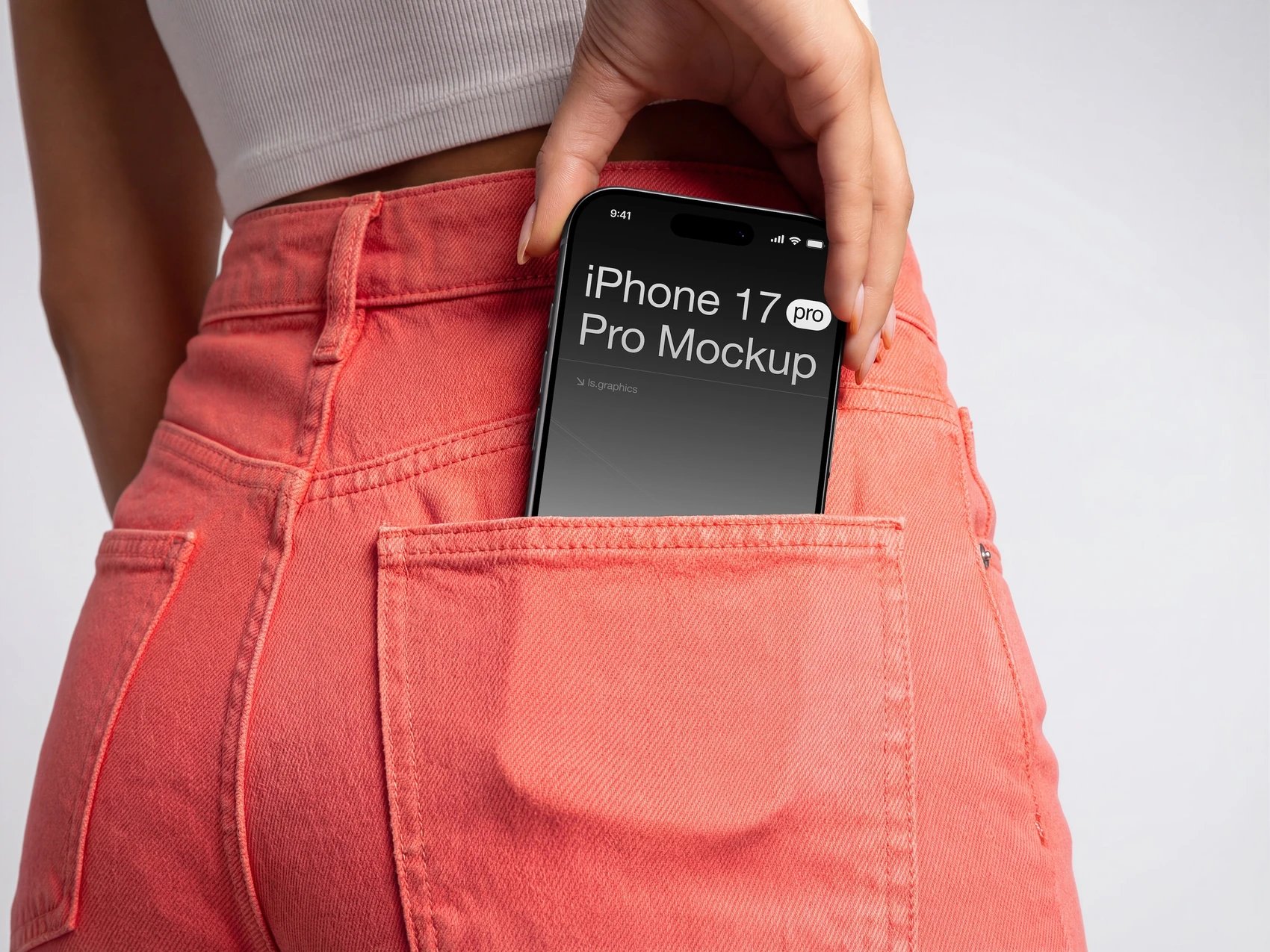 Person med en iPhone i baglommen på et par koralfarvede jeans