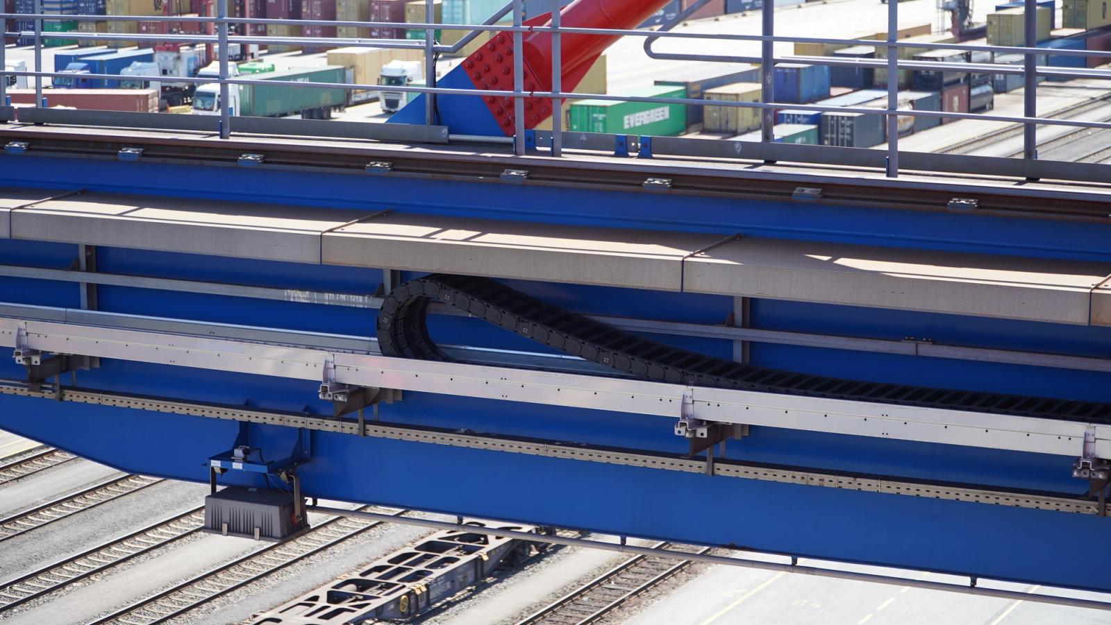 igus energy chain in guided rail on container crane beam with container yard