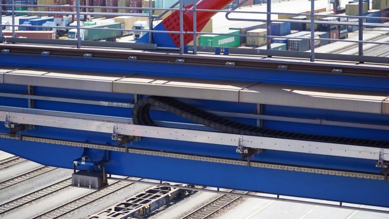 igus energy chain in guided rail on container crane beam with container yard