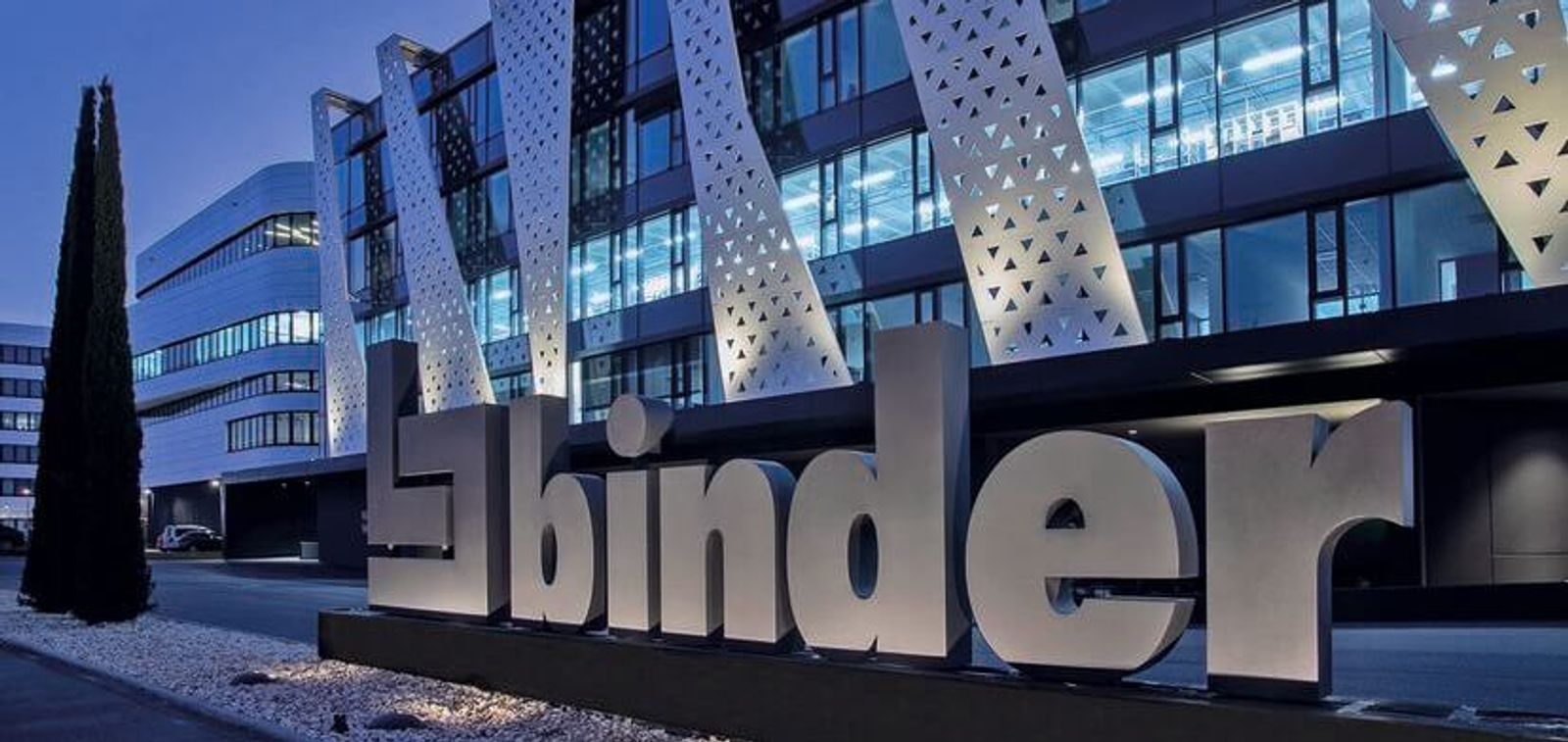 binder company headquarters with illuminated logo at night