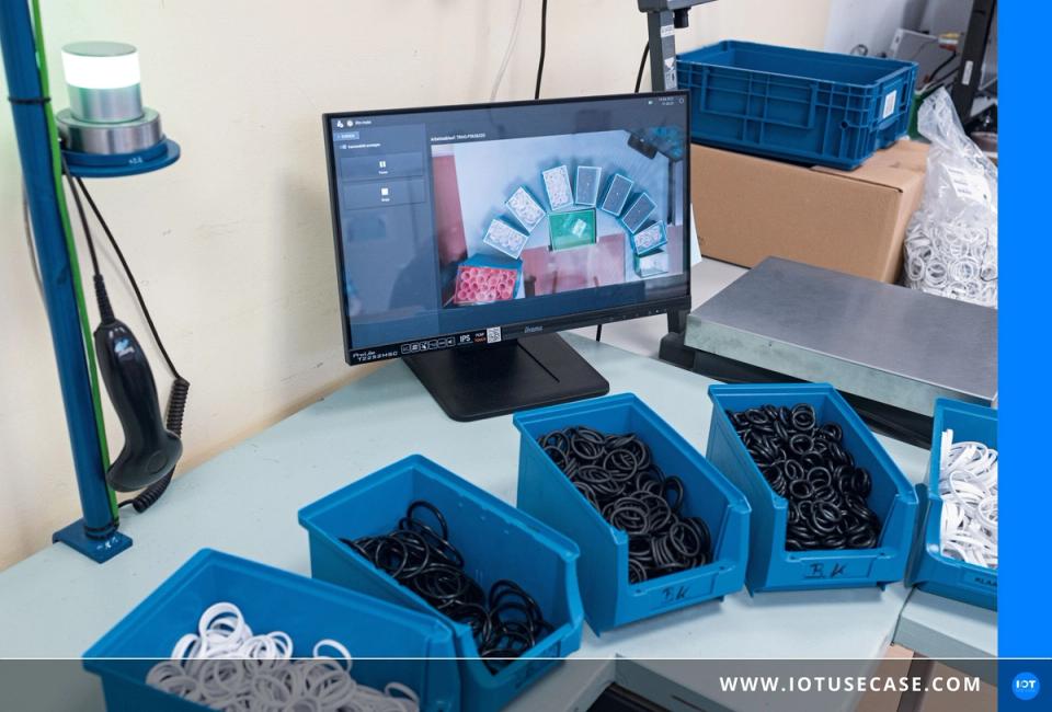 Werker beim Verpacken von Kleinteilen in der Lenne-Werkstatt, geführt vom kamerabasierten Assistenzsystem ifm mate über ein Display