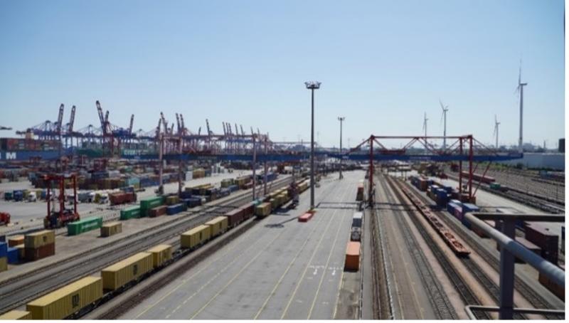 Container terminal Hamburg with gantry cranes, freight trains and wind turbines
