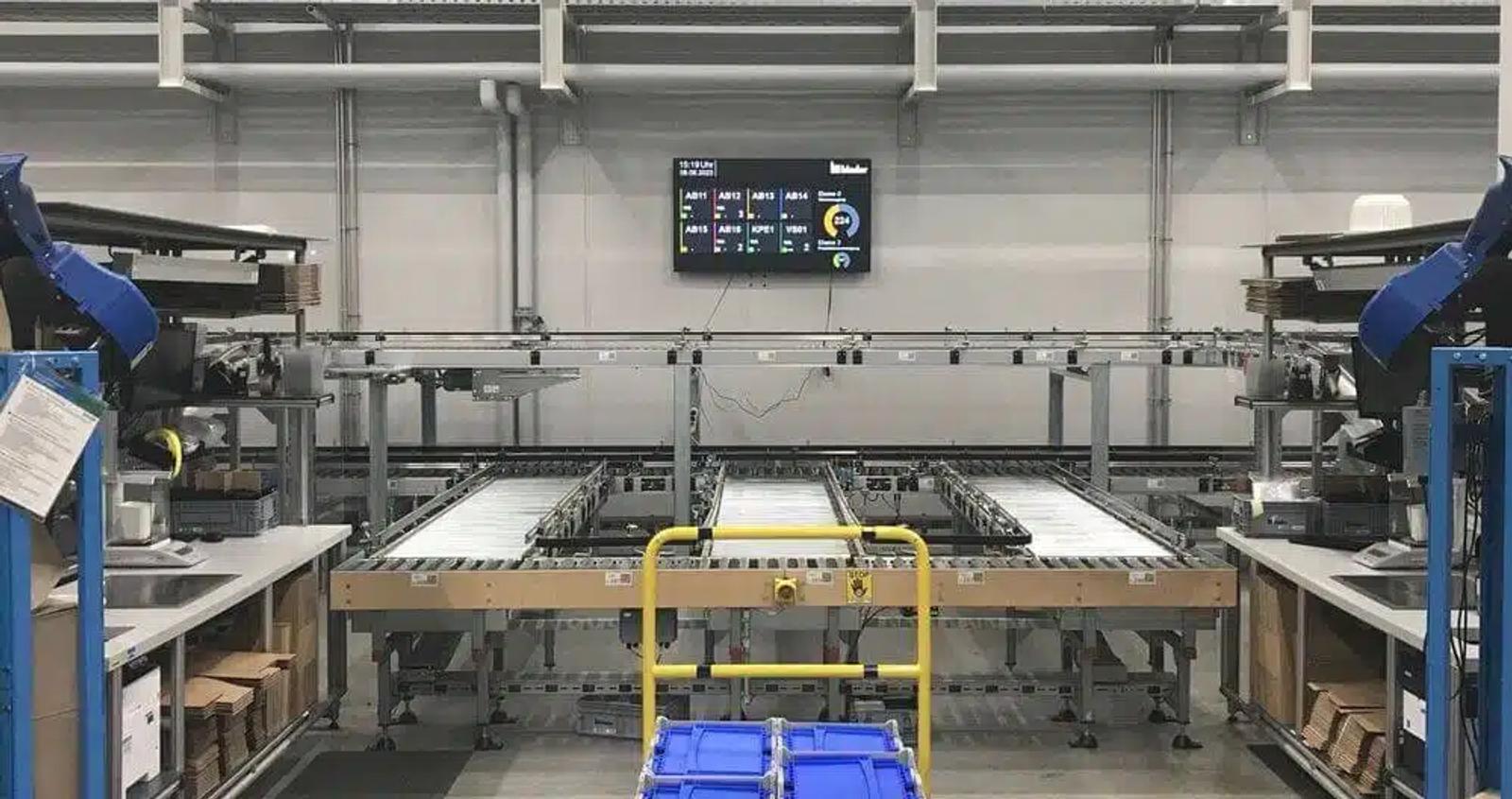 binder production floor with conveyor belt, robot arms and shopfloor dashboard
