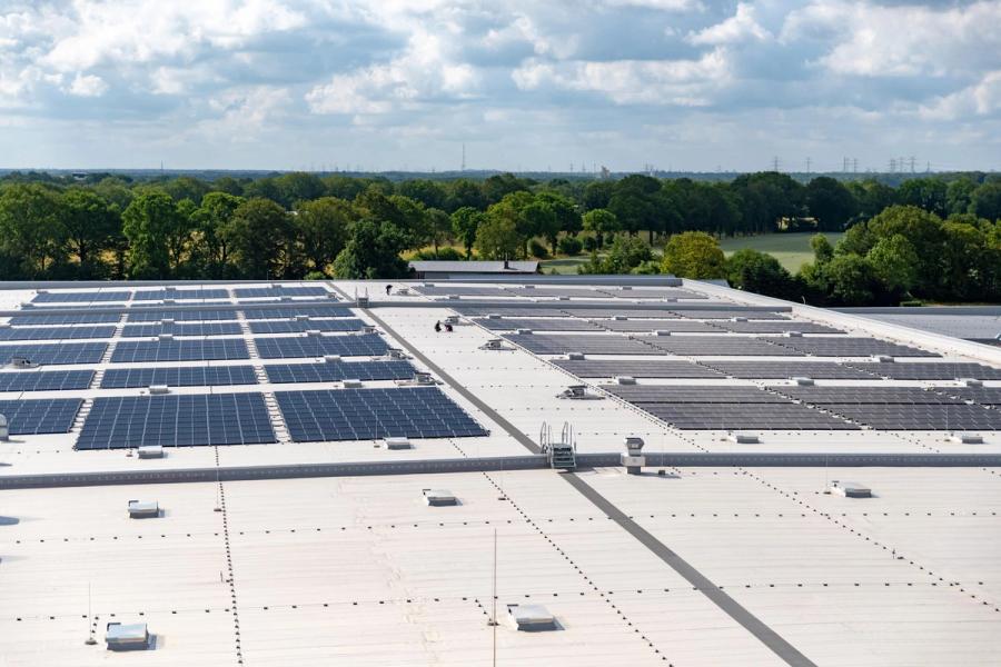 Luftaufnahme einer großen Photovoltaik-Anlage auf einem Industrieflachdach