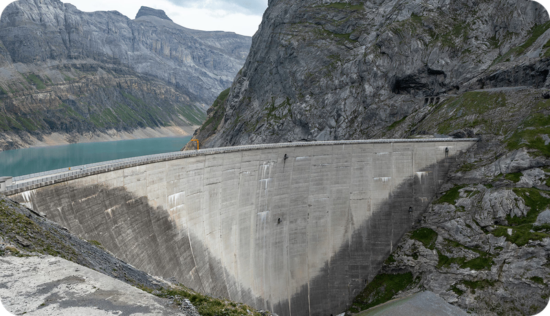 Bogenstaumauer Limmernsee zwischen steilen Felswänden in den Glarner Alpen, dahinter der türkisfarbene Stausee