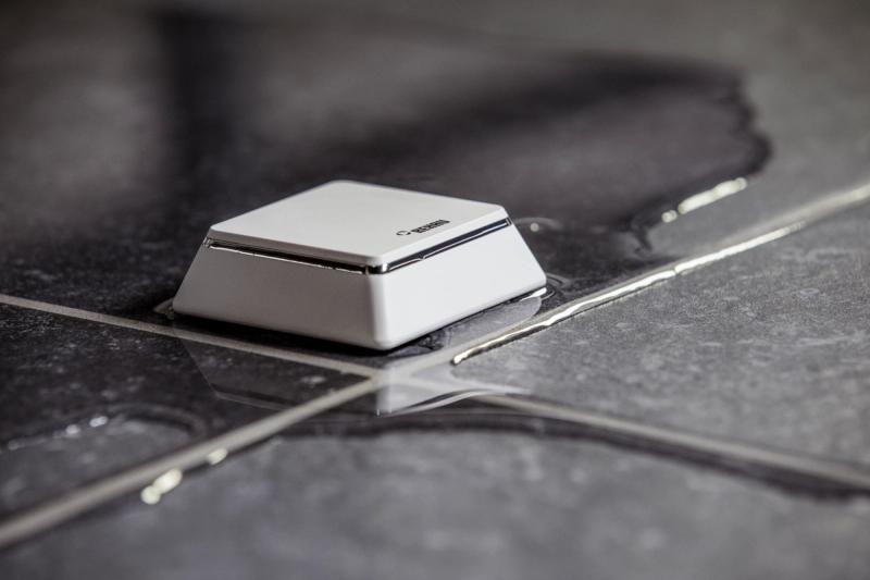 Kleiner IoT-Wassersensor auf nassen Fliesen zum Erkennen von Leckagen
