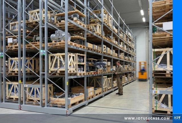 Warehouse worker inspecting high-bay racking system with mobile shelving – Dexion & Cumulocity IoT condition monitoring