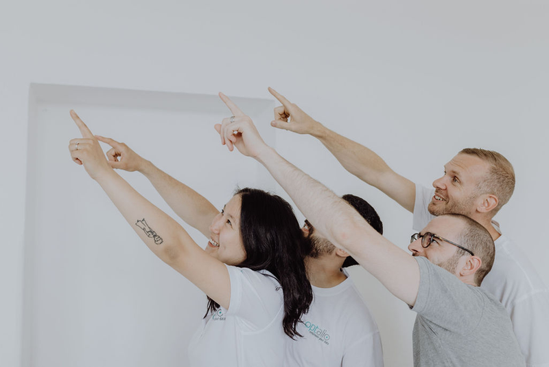 Team zeigt gemeinsam nach oben – Zusammenarbeit bei Prozessoptimierung