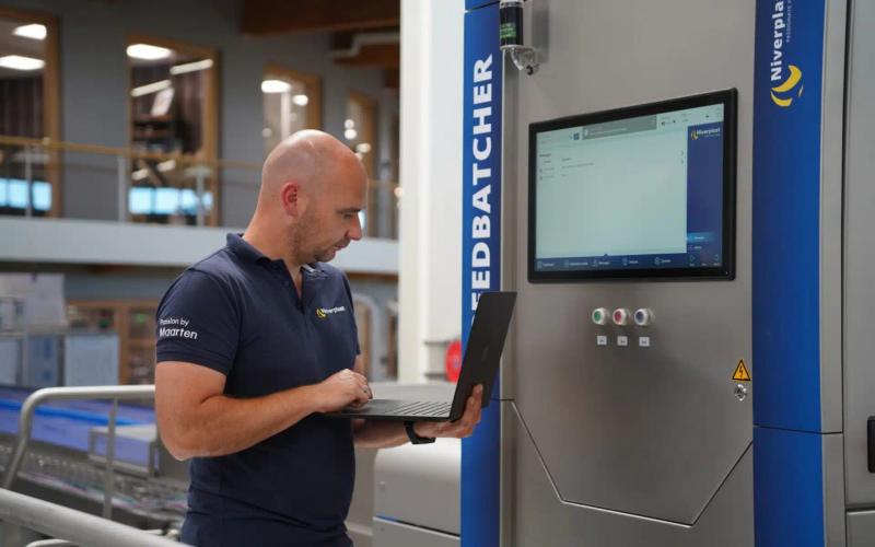 Niverplast-Techniker mit Laptop vor FEEDBATCHER Verpackungsmaschine mit IXON-Integration