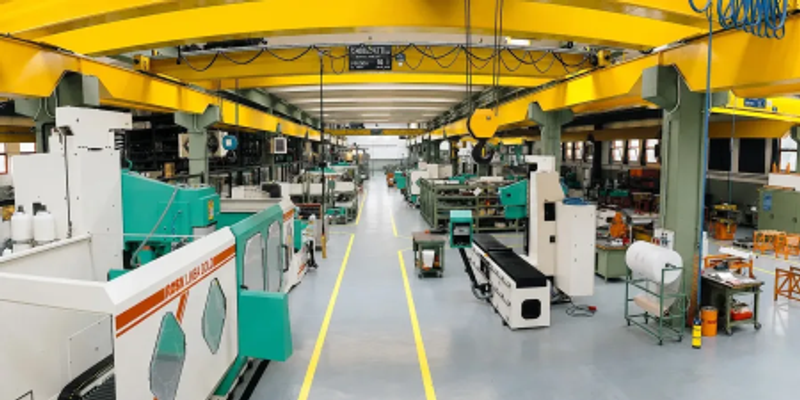 View along the Rosa Ermando shop floor with Linea Gold grinding machines beneath a yellow overhead crane
