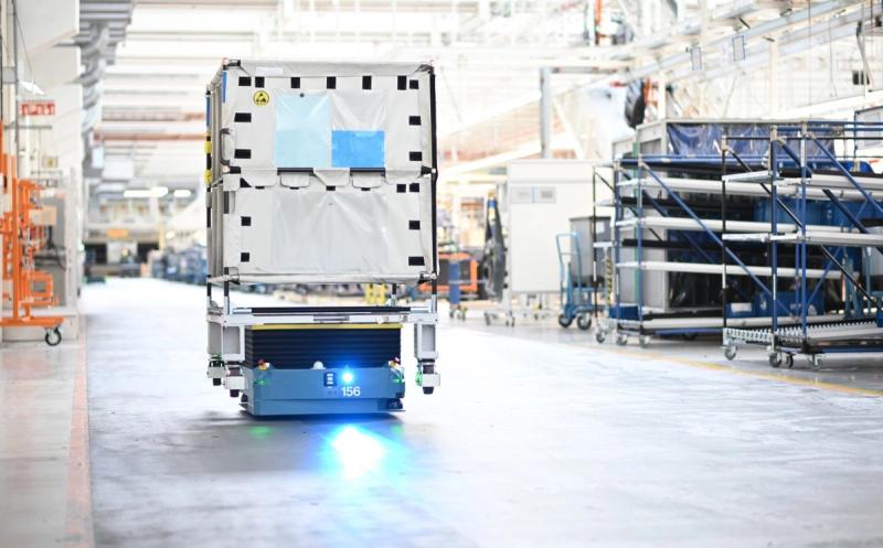Autonomous AGV vehicle transports load through production hall per VDA 5050
