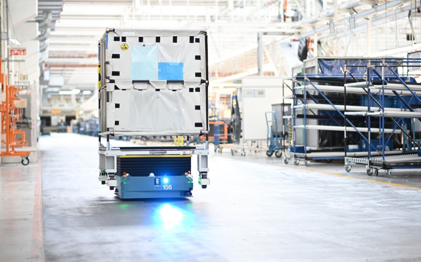 Autonomous AGV vehicle transports load through production hall per VDA 5050