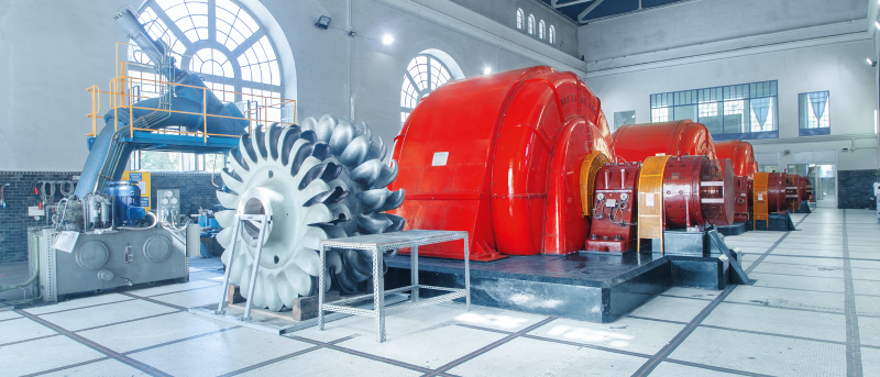 CVA Wasserkraftwerk-Maschinenhalle mit Pelton-Wasserrad und roten historischen Generatoren