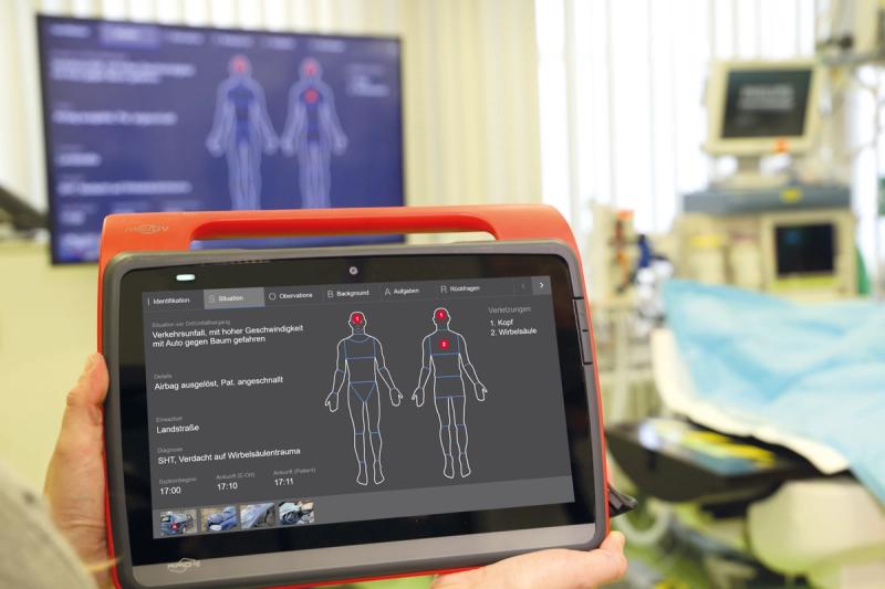 Notarzt-Tablet mit Patientenakte und Körperkarte für Verletzungsdokumentation im Notfallraum