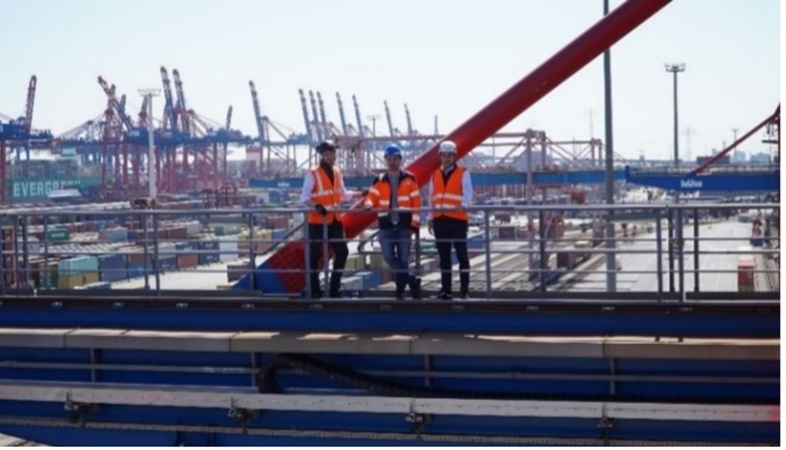 Three igus engineers on container crane at Port of Hamburg with safety equipment