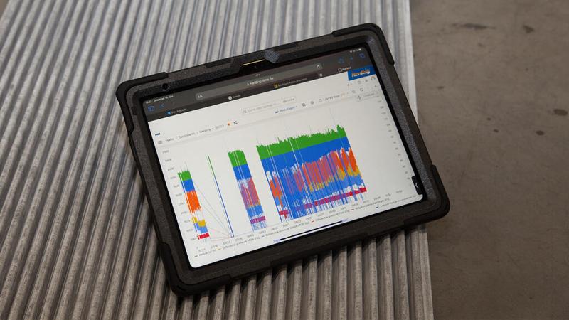 Robustes Tablet mit buntem Filteranlagen-Monitoring-Dashboard auf Wellblech-Untergrund