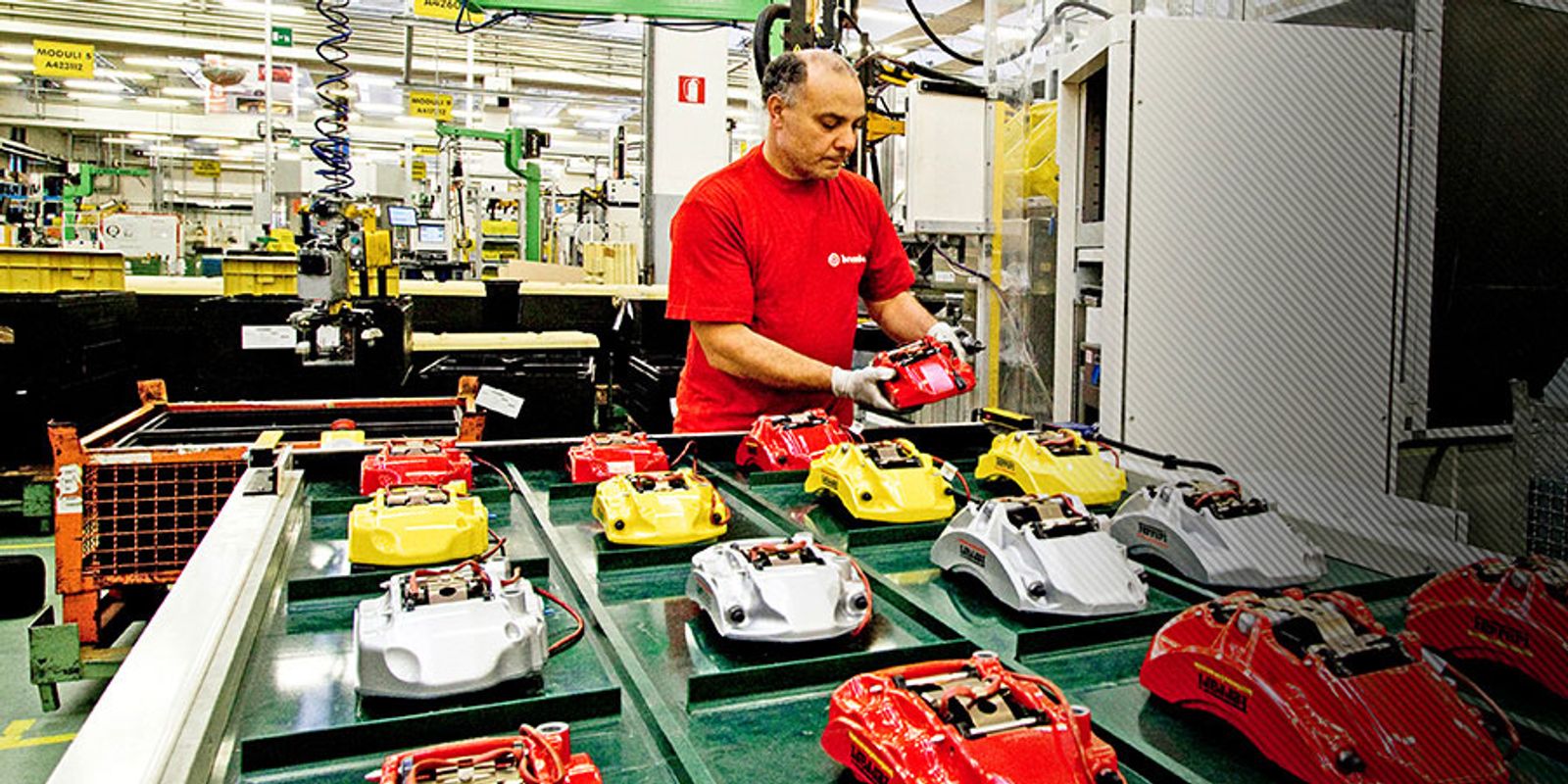 Brembo brake caliper assembly: various colored brake calipers on production table