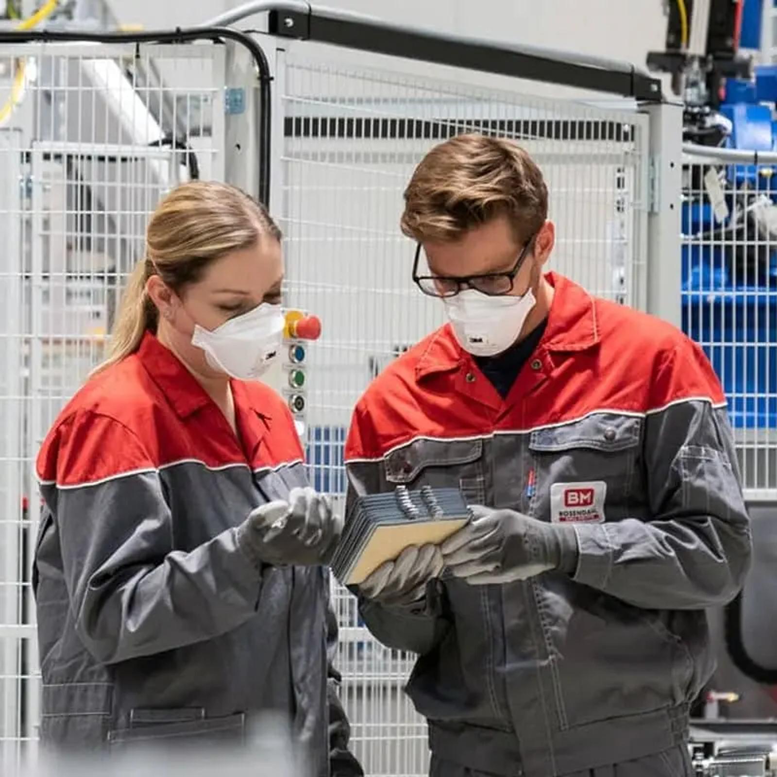 Rosendahl Mitarbeiter prüfen Kabelprodukt in der Produktionshalle mit Schutzausrüstung
