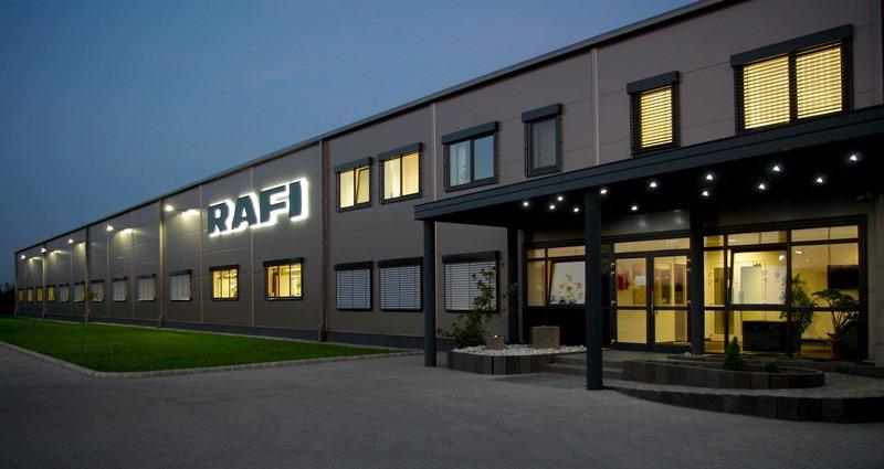 RAFI Unternehmensgebäude mit beleuchtetem Logo bei Dämmerung