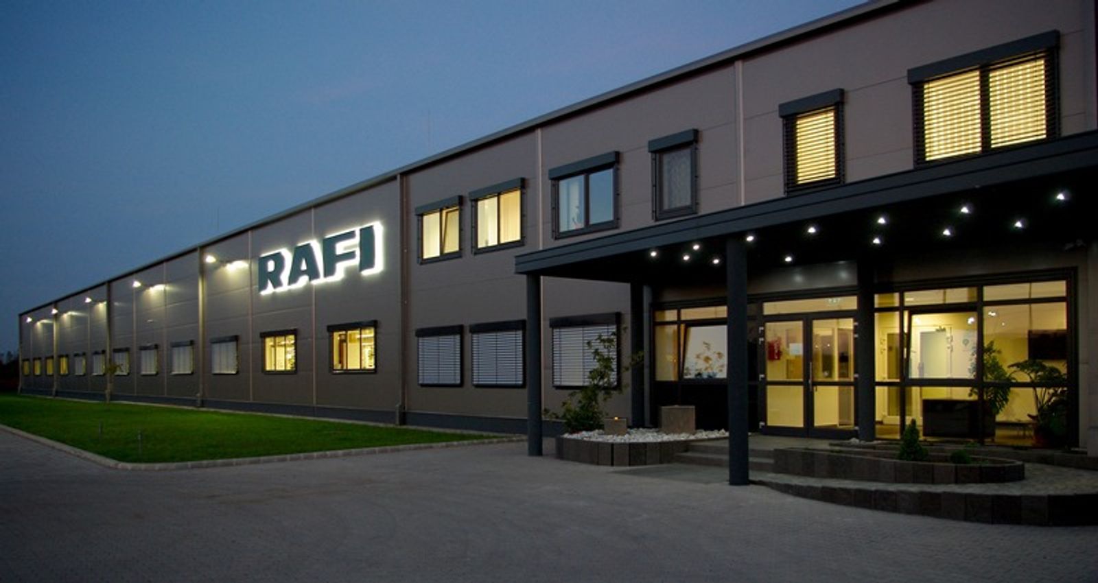RAFI company building with illuminated logo at dusk