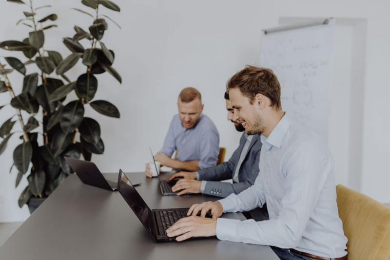 Zwei Mitarbeiter im Meeting mit Laptops bei der Prozessplanung
