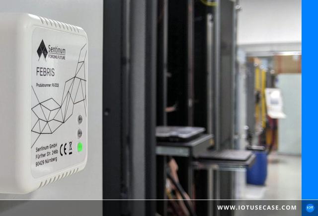 Compact Febris CO2 indoor air sensor from Sentinum with traffic-light LEDs on the wall of an office room