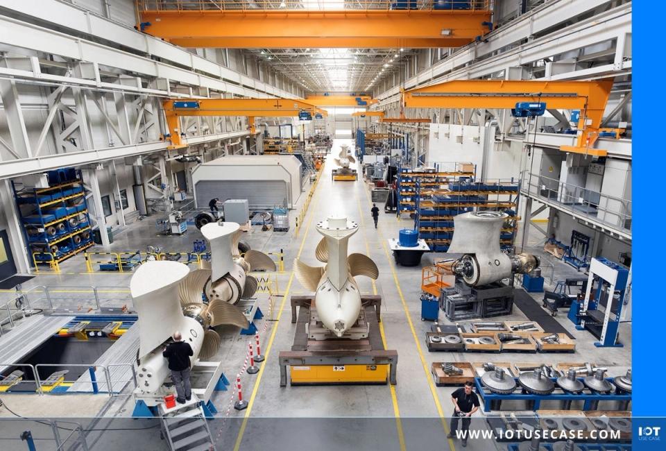 Industrielle Schiffsbau-Halle mit großen Propellern und Antriebskomponenten an mehreren Montagestationen, Beschäftigte bei der Arbeit.