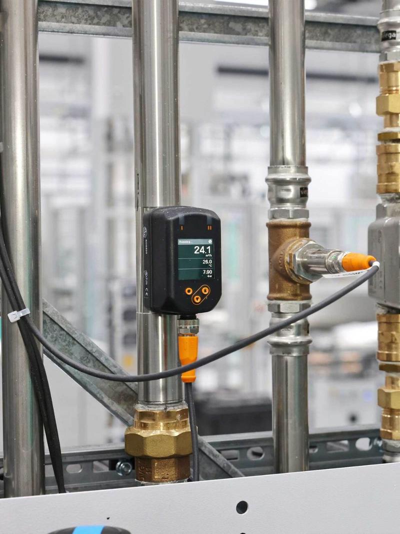 Druckluftzähler SD8500 mit Display an einer Rohrleitung, per IO-Link-Kabel angeschlossen