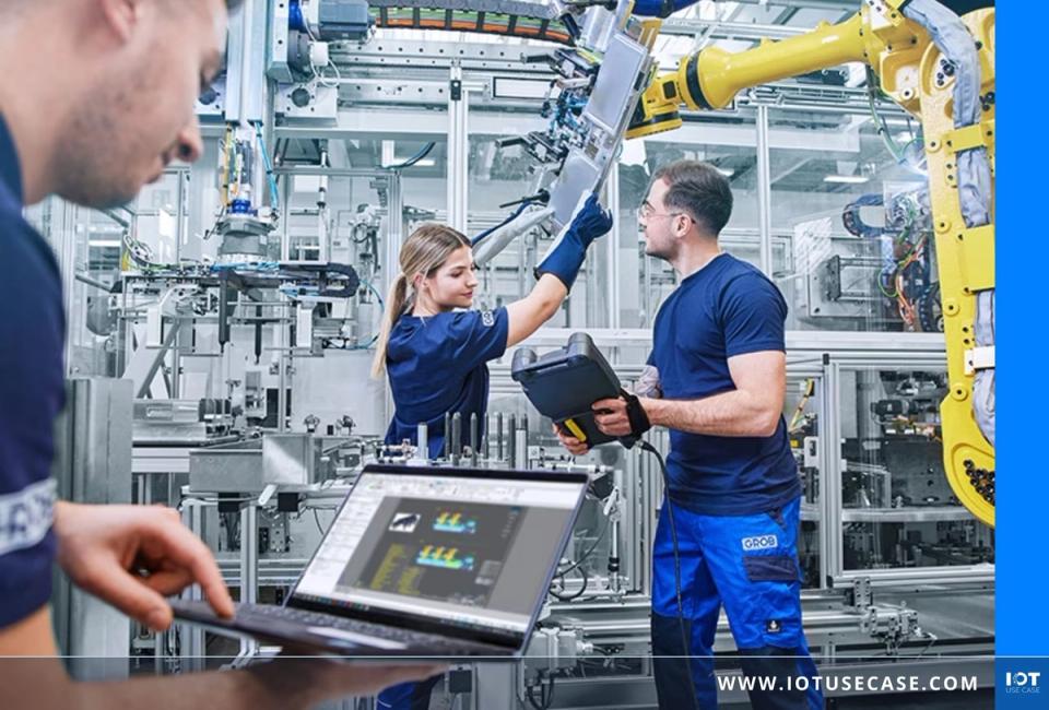 GROB-WERKE Mitarbeitende an einer Roboter-Produktionslinie werten Maschinen- und Projektdaten auf einem Dashboard-Laptop aus