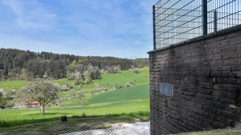 Water works building in rural setting with fields and forest edge