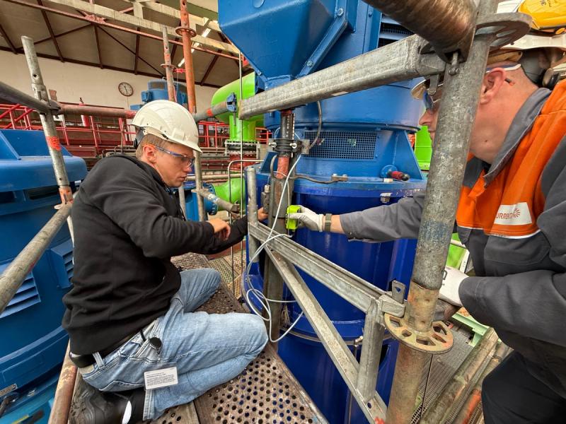 Technician retrofitting a pump with a battery-powered LoRaWAN vibration sensor