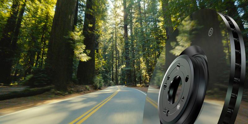 Brembo brake disc in front of forest road - digital transformation high-performance brakes