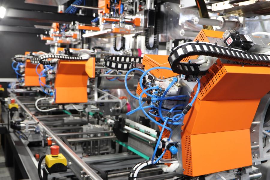 Automatisierungsmodul mit orangen Energieketten und Pneumatikleitungen