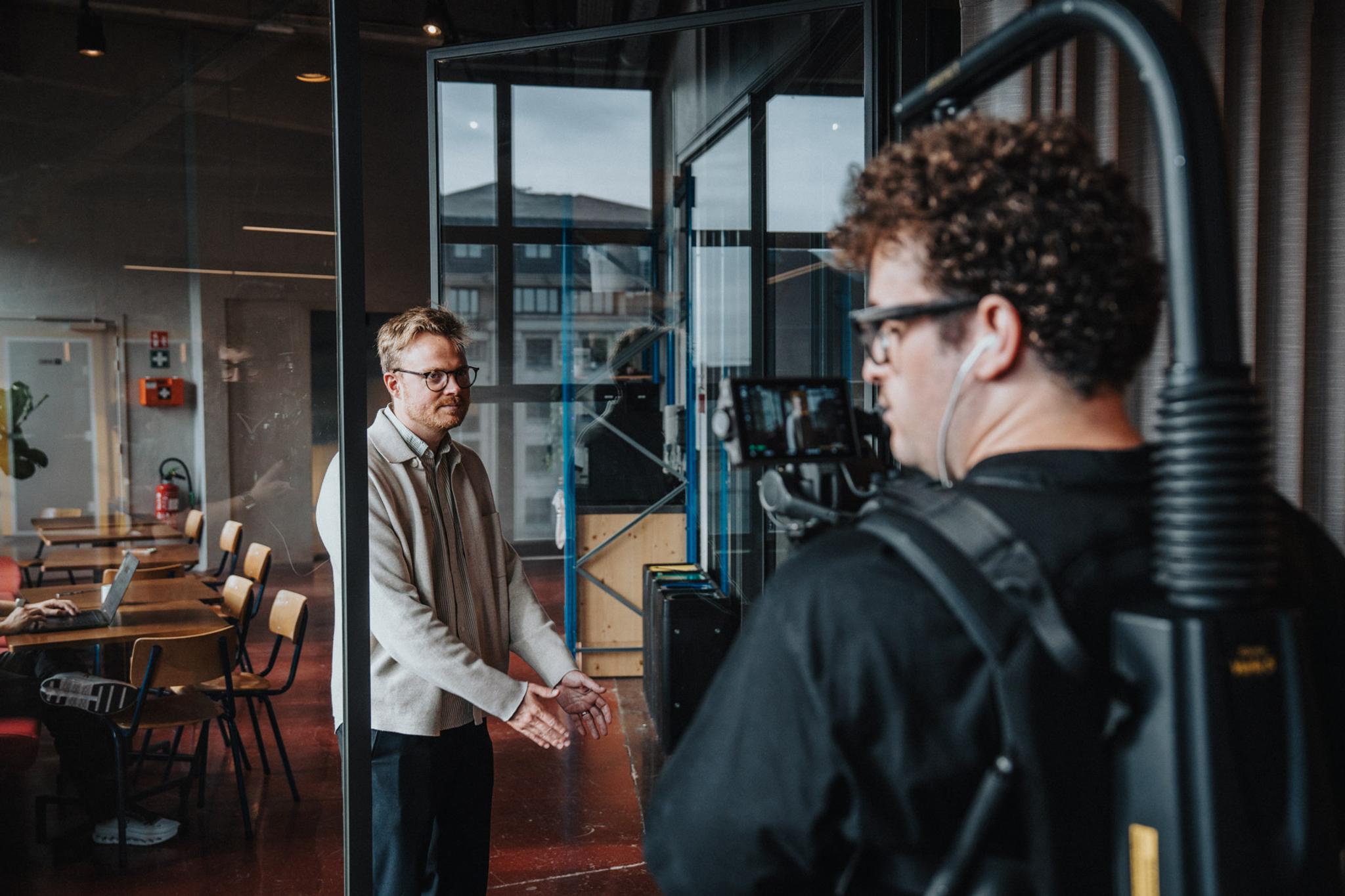 Achter de schermen: cameraman met steadicam filmt een spreker bij Falcon